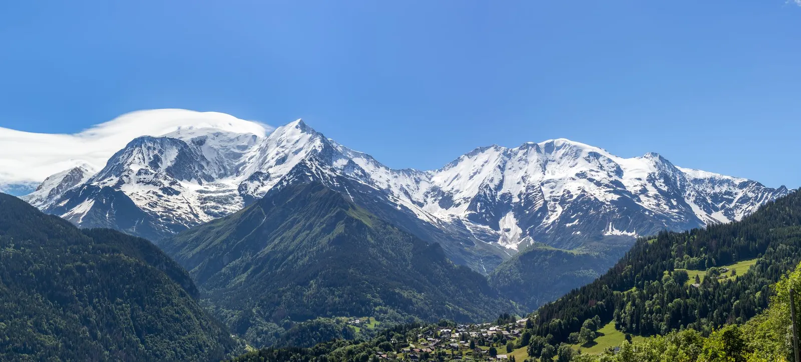 Sommets des Alpes françaises au-dessus d'une vallée boisée