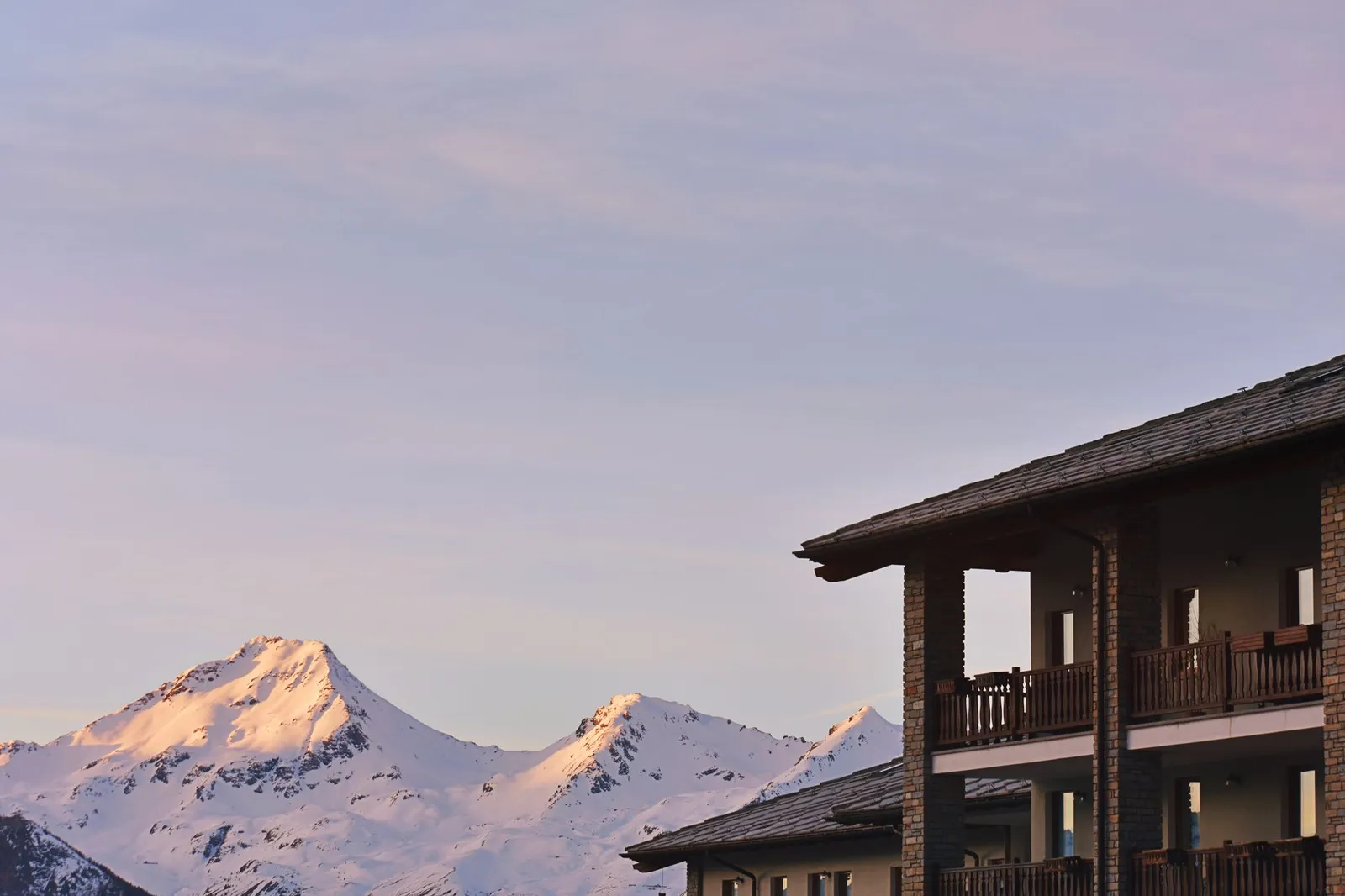 Chalet de montagne en bois avec balcon enneigé